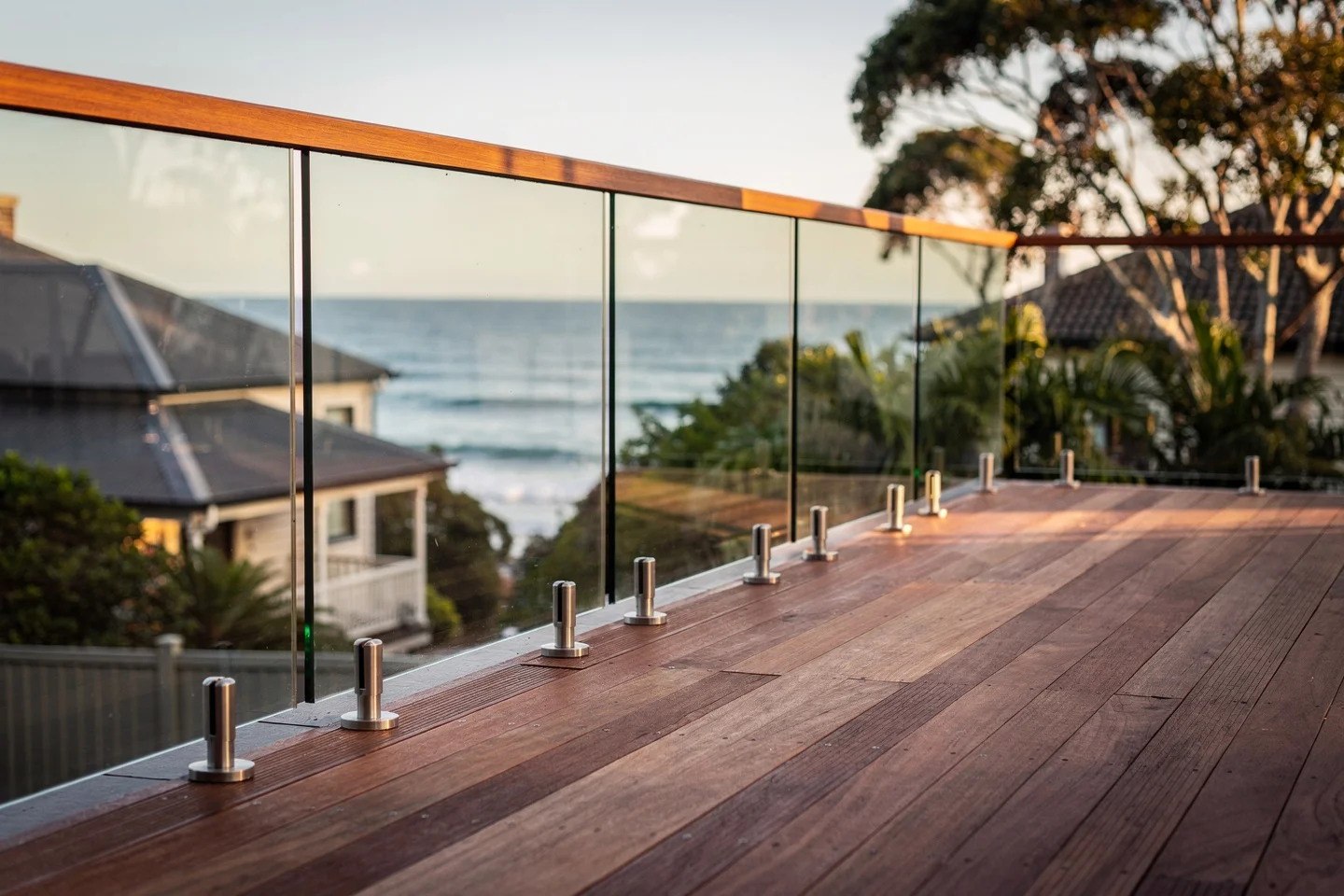 A frameless glass balustrade on a Central Coast deck, stainless steel spigots visible at the base